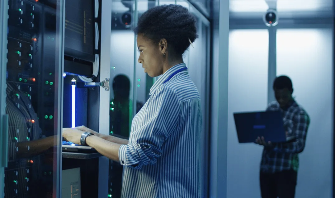 An engineer working at a server rack in a data centre